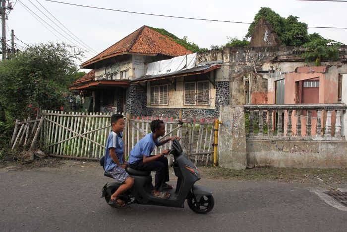 pengendara sepeda motor melintasi bangunan bekas SMA 17 (I)
