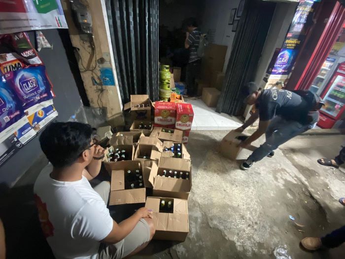 TAK BERIZIN: Ditreskrimsus Polda DIY saat menggerebek dan menyita ratusan botol miras dari sebuah toko di Sewon, Bantul.