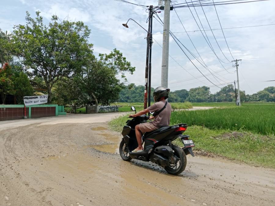 Baliho protes jalan rusak yang dipasang oleh warga