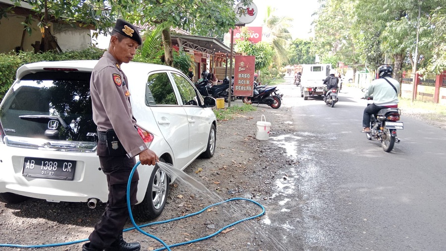 PERBAIKAN: Personel Polsek Pengasih saat membersihkan bekas beton yang baru kering.