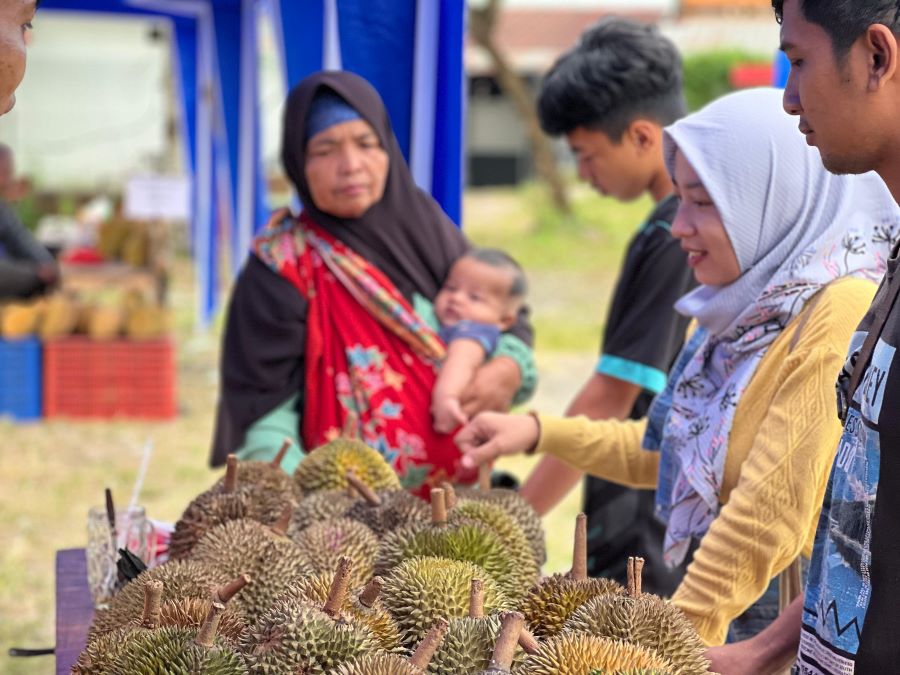 Pengunjung sedang memilih durian dalam Pasar Durian Runtuh yang digelar di area parkir atas HeHa Sky View di Kapanewon Patuk. Rabu (12/2/2025).