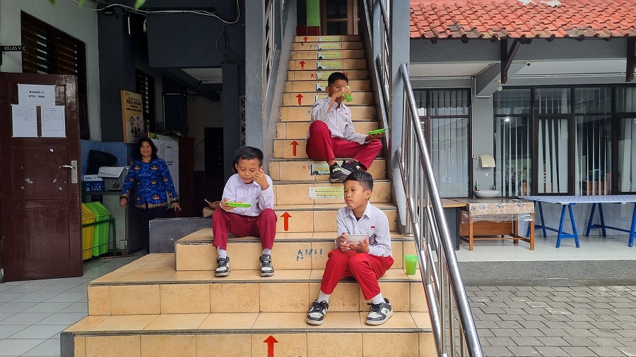 Para siswa SDN Kotagede 1 memakan bakal dan membeli makan di kantin sekolah, karena program MBG di sekolah mereka ditunda.