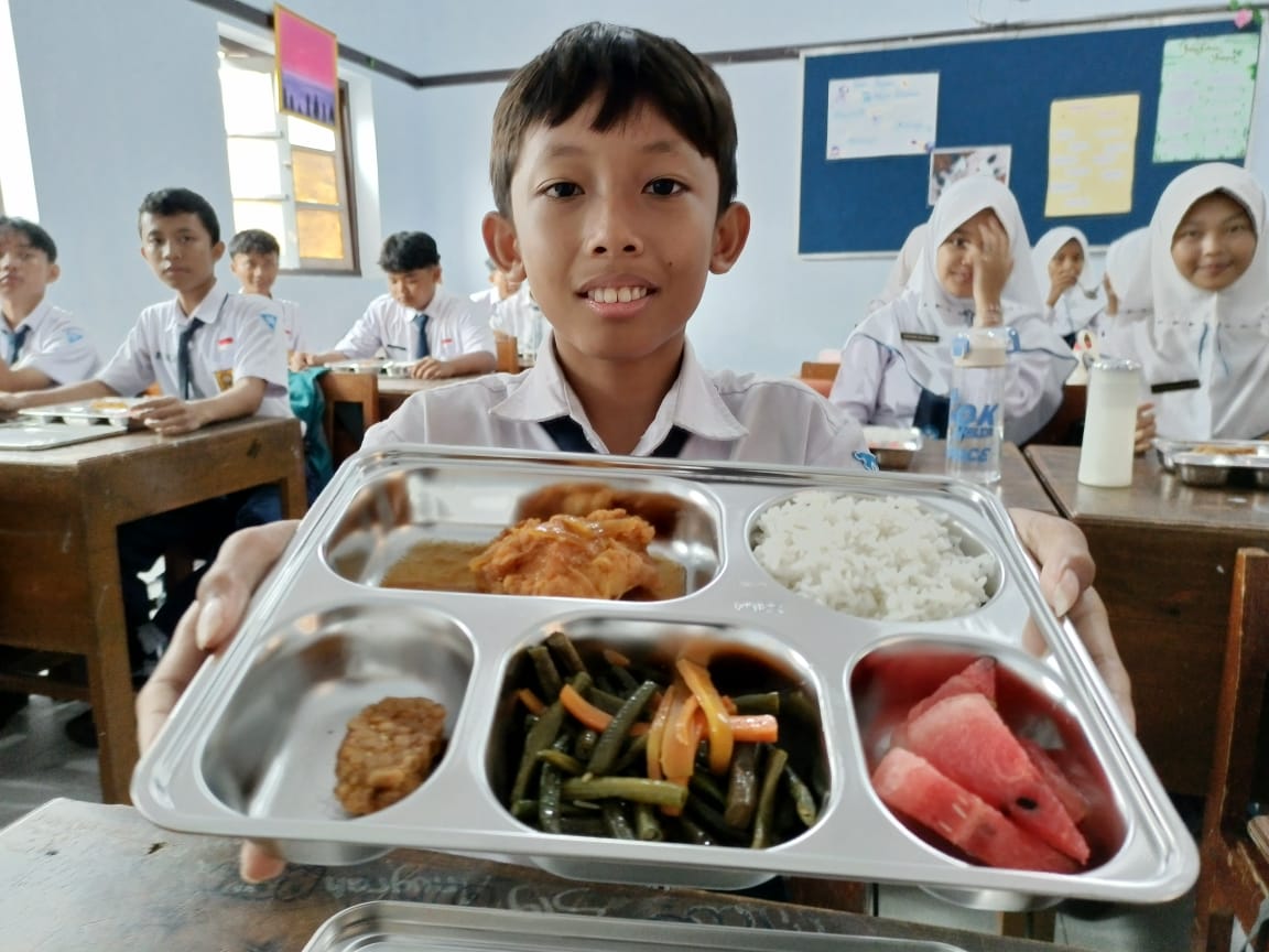 Siswa SMP Negeri 1 Kebumen menunjukkan paket menu Makan Bergizi Gratis (MBG) yang baru dilaksanakan perdana di Kebumen.