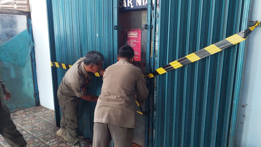 Personel Satpol PP melihat kondisi ruangan dan menyegel bangunan.