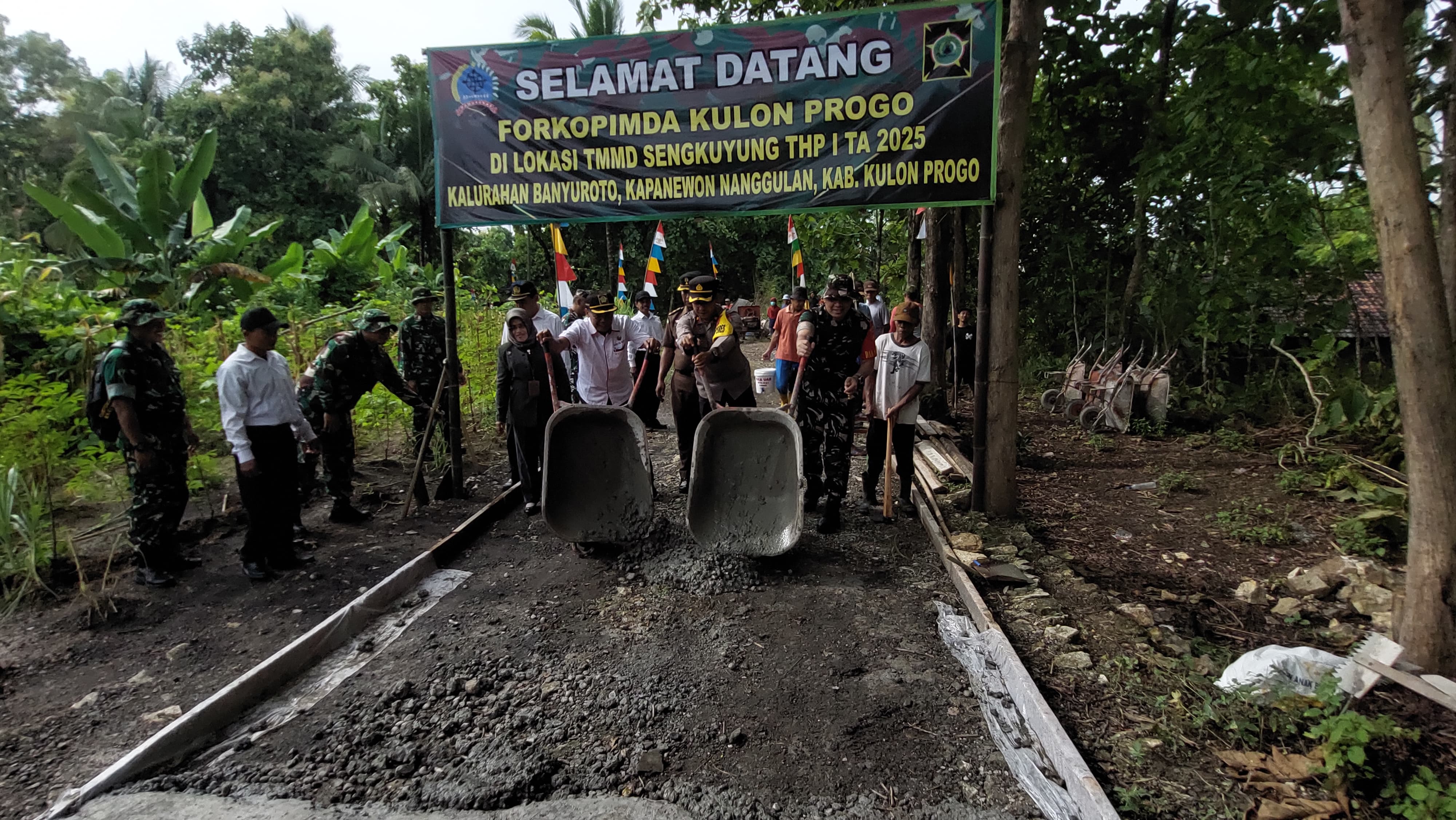 SIMBOLIS: Dandim 0731 Kulon Progo menuangkan rabat beton di jalan Kalurahan Banyuroto.&nbsp;