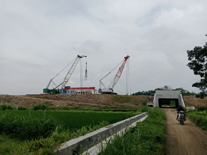 AKSES UTAMA: Jalan desa yang berada di bawah pembangunan Tol Jogja-Solo di Pundung, Tirtomartani, Kalasan tetap bisa dilewati warga. Namun, satu jalan desa lainnya, masih tertutup