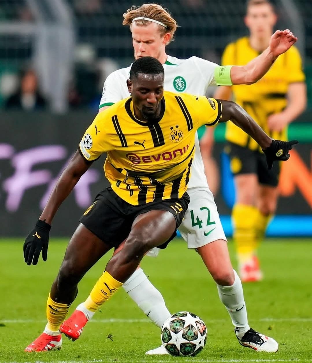 Penyerang Borussia Dortmund, Serhou Guirassy (kuning) coba lewati hadangan pemain Sporting CP pada leg kedua playoff fase gugur Liga Champions di Signal Iduna Park