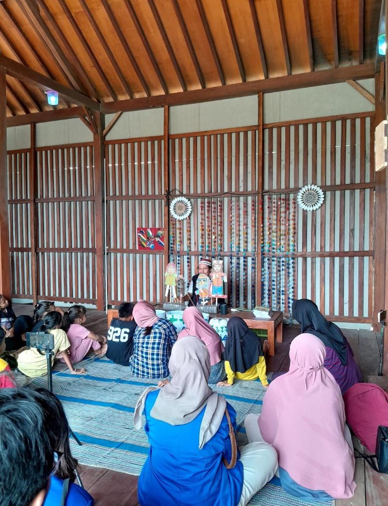 ANTUSIAS: Anak-anak pesisir Bantul saat melihat pementasan wayang limbah plastik difabel yang meliterasikan penyandang disabilitas.