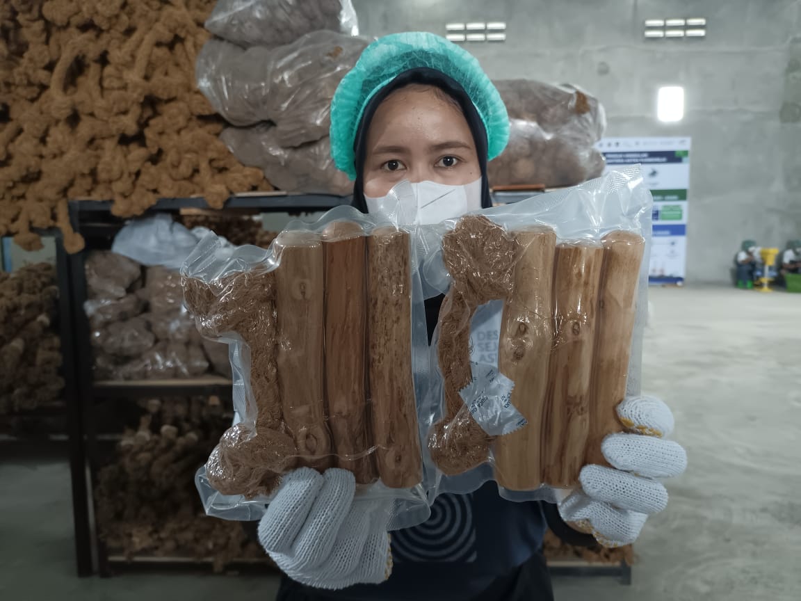 Pekerja menunjukkan produk kerajinan tangan berupa mainan anjing yang diminati pasar mancanegara.