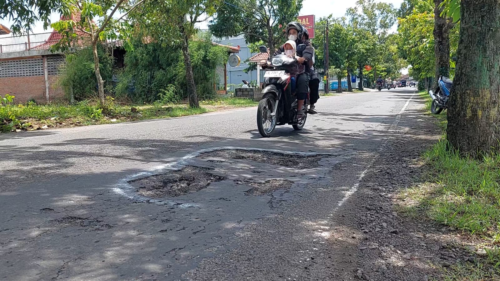 BERHATI-HATI: Pengguna jalan melintas di jalan raya yang kondisinya berlubang. Peningkatan jalan mantap di Kulon Progo tak kunjung terealisasi.