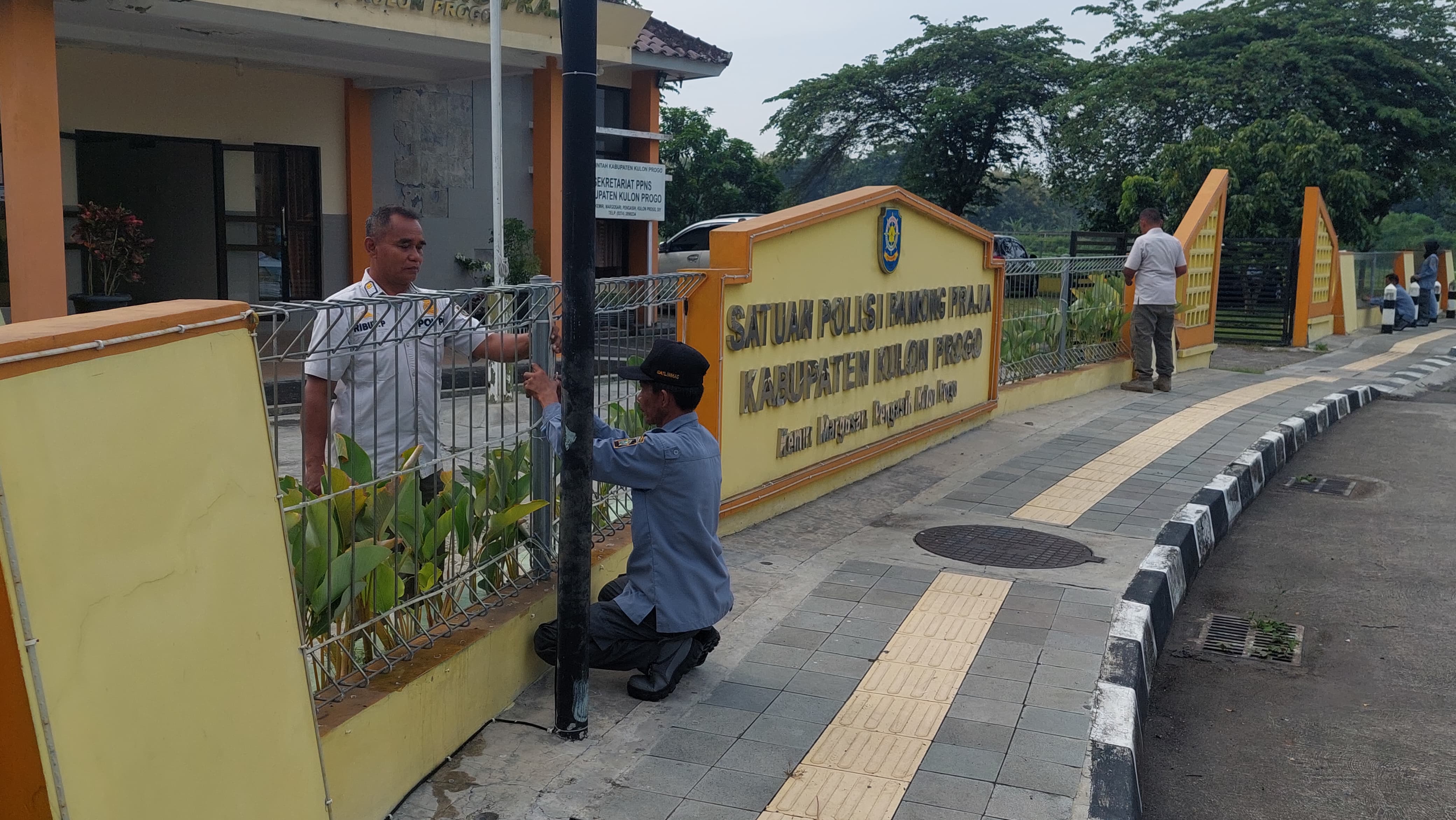 DICOPOT: Personel Satpol PP membongkar lampu berbentuk geblek renteng di pagar kantornya.&nbsp;