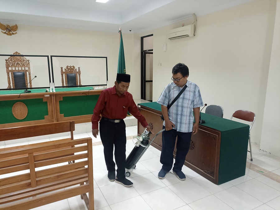 Lurah nonaktif Maguwoharjo Kasidi (kiri) didampingi anaknya beranjak keluar dari ruangan sidang usai menjalani sidang nota pembelaan di PN Tipikor HI Kamis (6/3/2025).