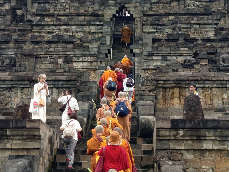 KHIDMAT: Puluhan biksuni dari berbagai negara naik ke struktur Candi Borobudur Jumat (7/3).