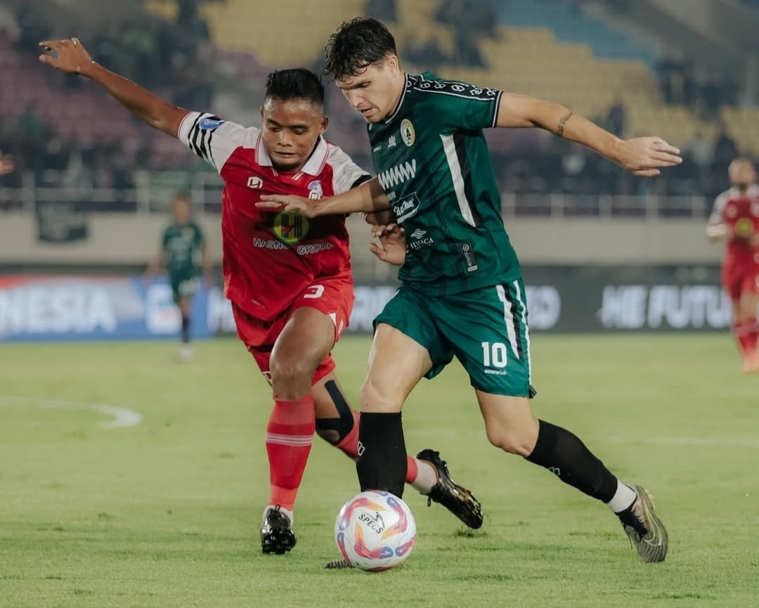 Gelandang PSS Sleman, Vico Duarte (hijau) coba melindungi bola dari pemain PS Barito Putera (merah).