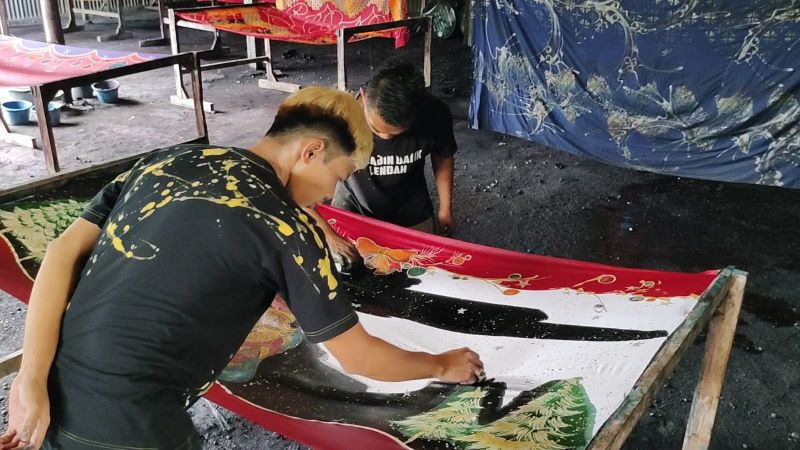 MEMBATIK: Pekerja batik di Lendah melakukan pewarnaan pada bakal kain.&nbsp;