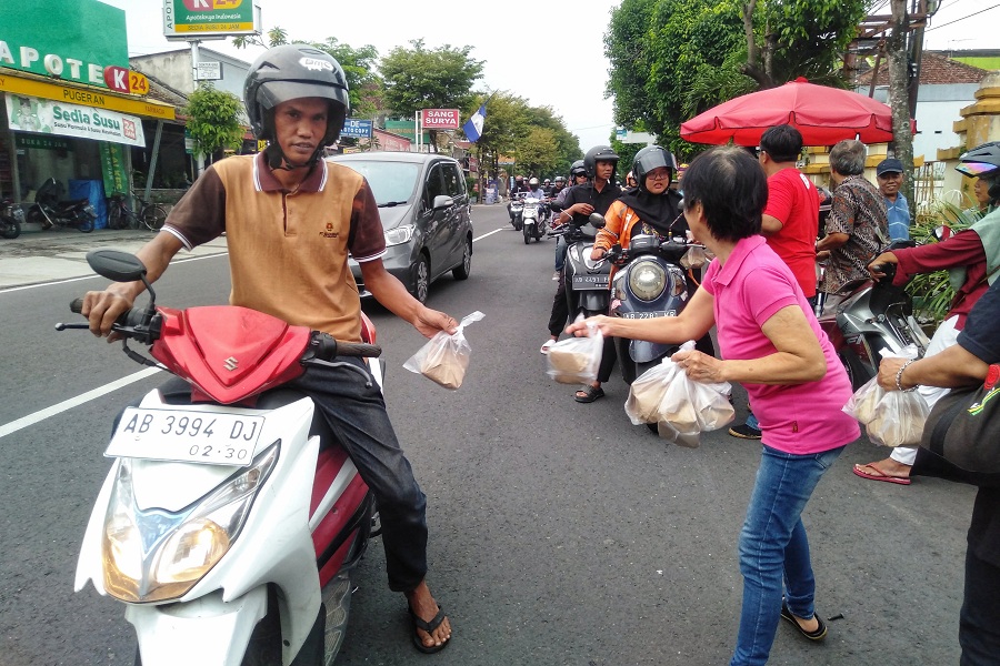 Sejumlah pengurus Gereja Katolik Hati Kudus Tuhan Yesus Pugeran membagikan takjil untuk berbuka puasa kepada para pengguna jalan yang melintas di depan gereja tersebut, Kota Jogja, Rabu (12/3/202).