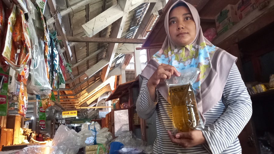 Ilustrasi penjual minyak goreng merek Minyakita di Pasar Imogiri, Marini saat menunjukan produknya.