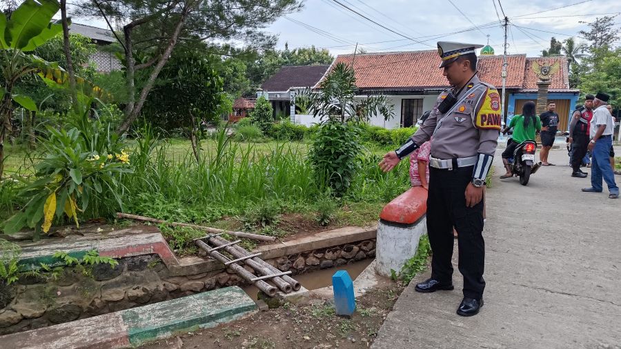 TKP: Personel kepolisian memeriksa tempat yang diduga balita tercebur di saluran irigasi.