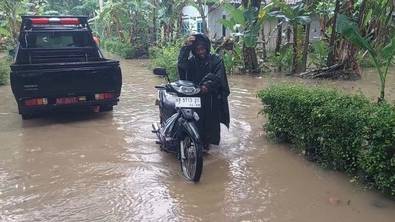 TERDAMPAK: Warga saat mendorong kendaraannya di wilayah yang terkena banjir di Kabupaten Kulon Progo.