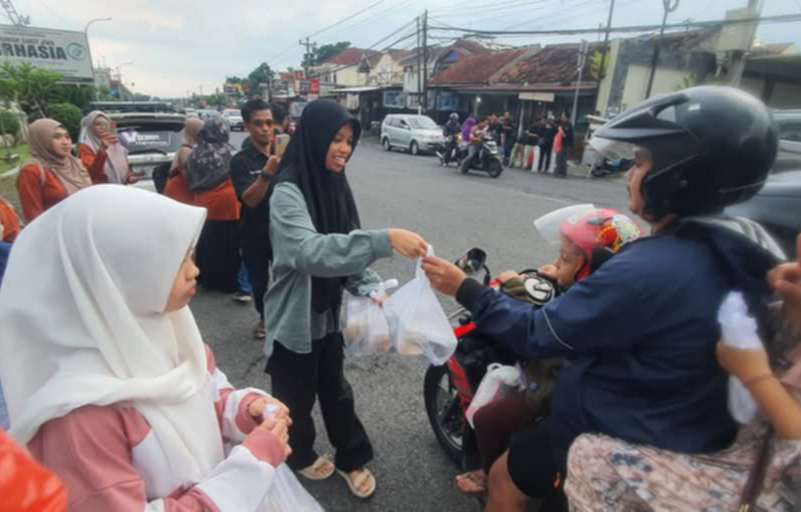 Komunitas bakul laptop Jogja membagikan takjil kepada pengendara yang melintas.