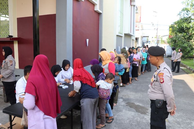 Warga mengantre membeli bahan pokok di pasar murah yang diadakan di halaman Mapolres Gunungkidul, Senin (17/3).