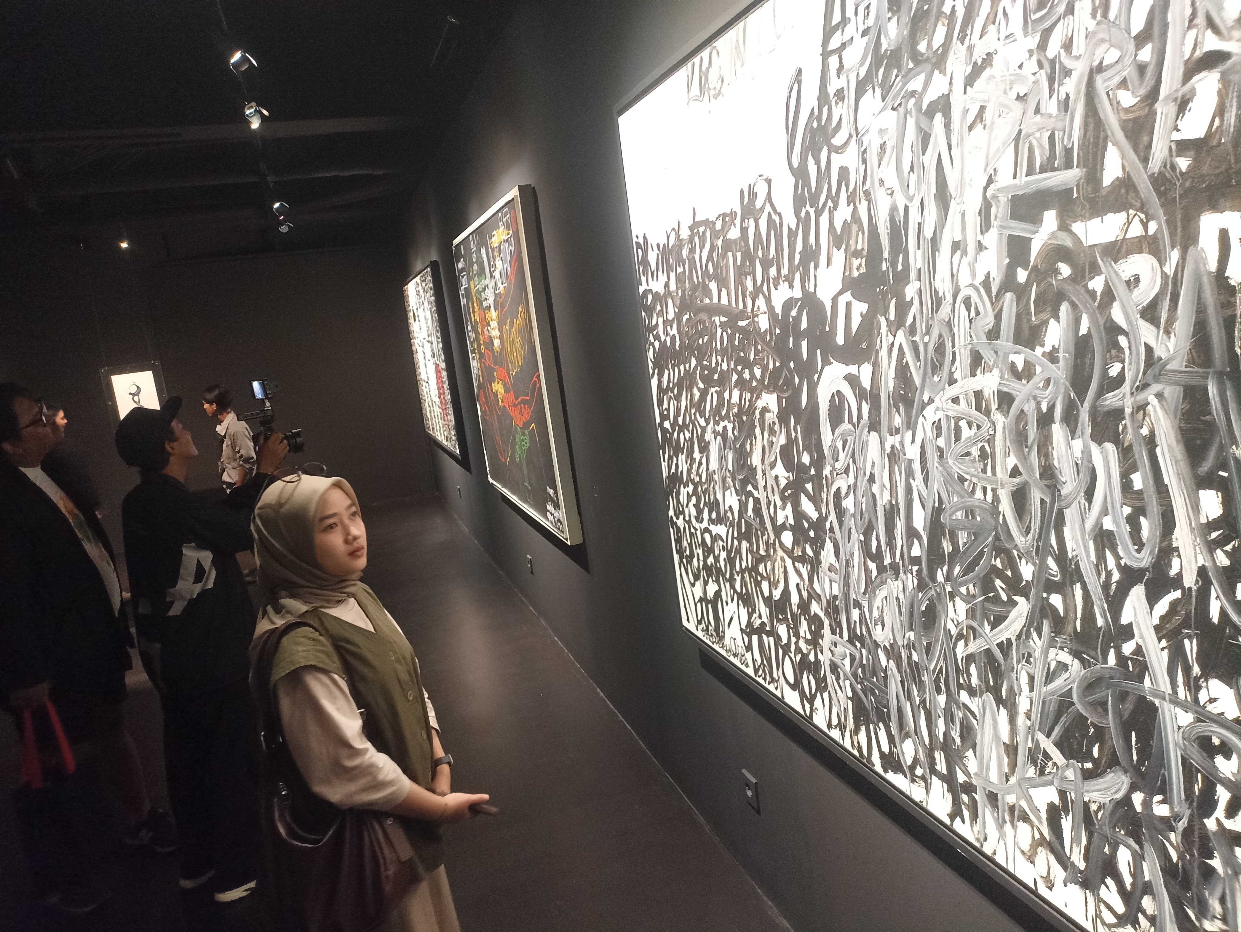 Foto: Pengunjung mengamati karya yang dipamerkan dalam pameran perjalanan artistik Bob Sick di Galeri Seni EDSU House, Kamis (20/3/2025).