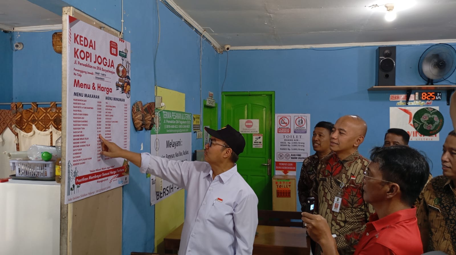 PASANG: Wali Kota Jogja Hasto Wardoyo saat memasang daftar harga di menu milik salah satu pedagang kuliner di kawasan sirip-sirip Malioboro pada Selasa (25/3/2025).