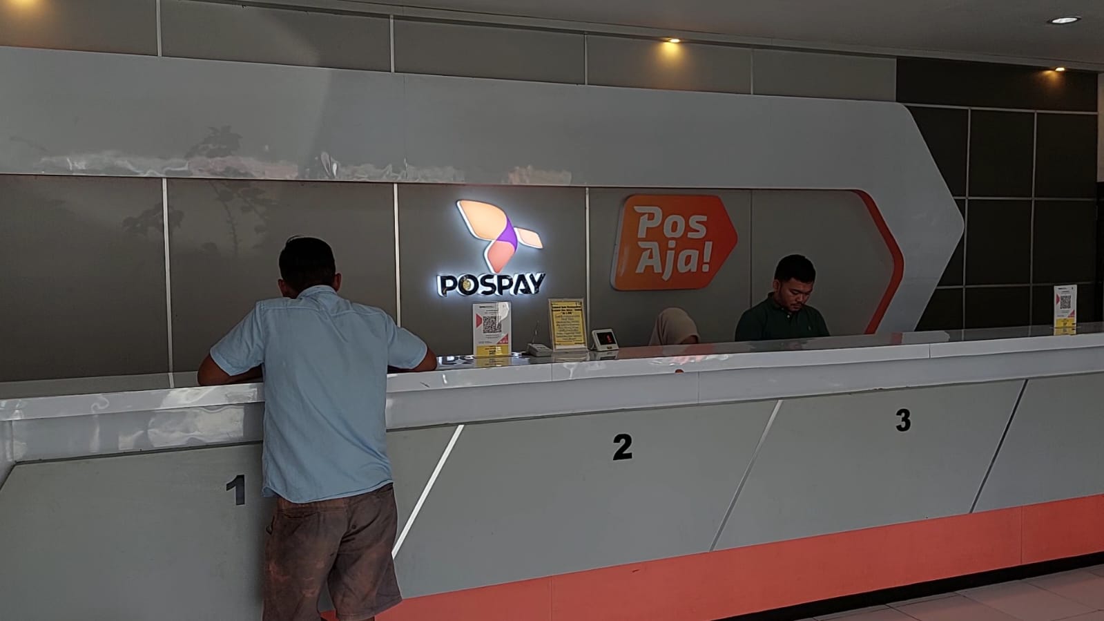 SUASANA: Pegawai kantor pos melayani pengujung yang mengirimkan paket.