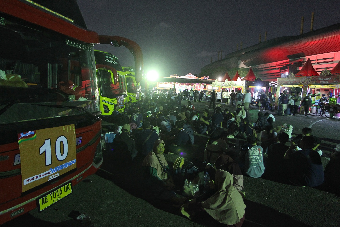 Pedagang Warmindo menunggu waktu keberangkatan menuju Kuningan, Jawa Barat, dalam program mudik gratis, di Stadion Mandala Krida, Rabu malam (26/3)