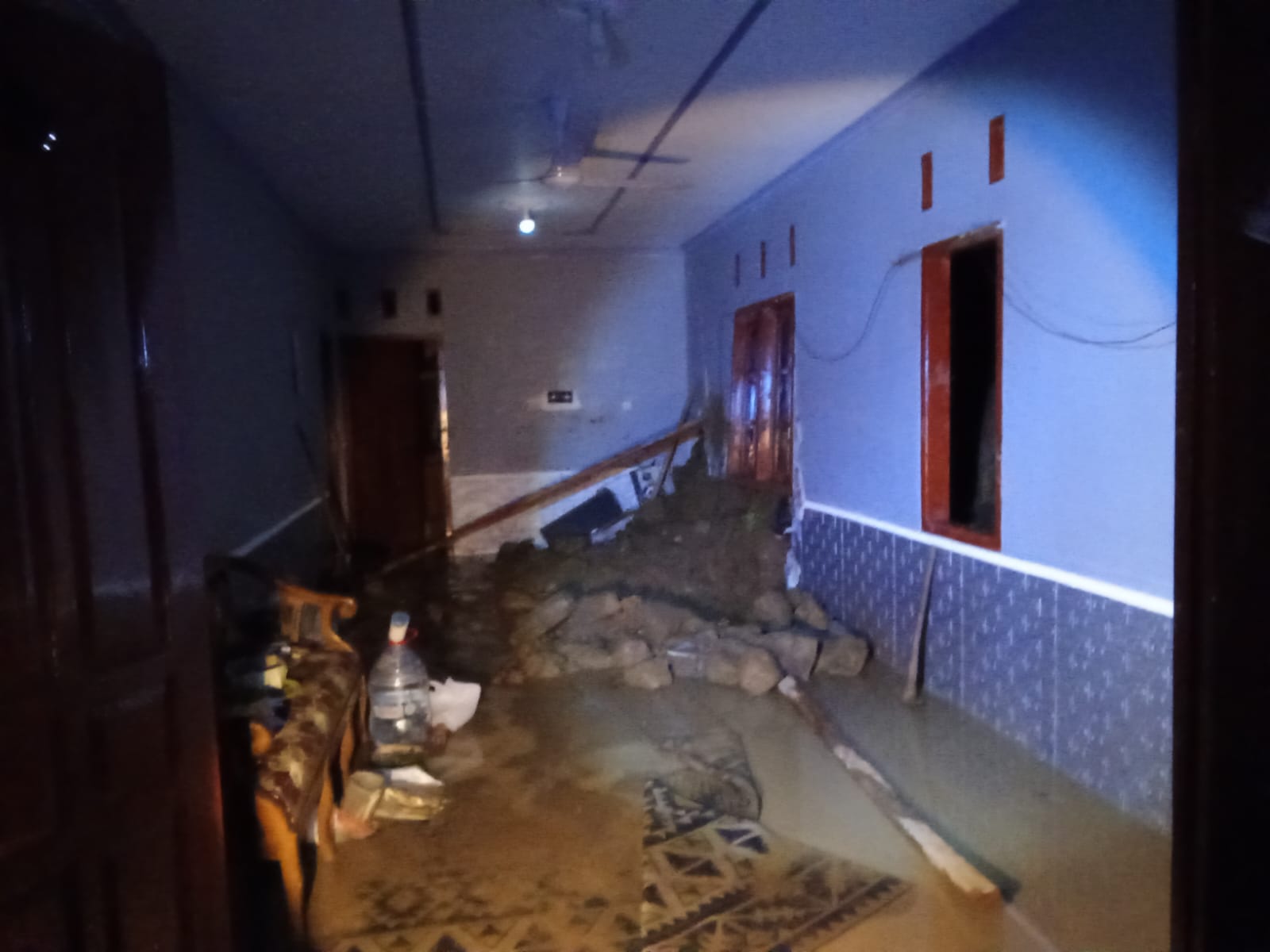 JEBOL: Material longsor merusak dinding rumah.