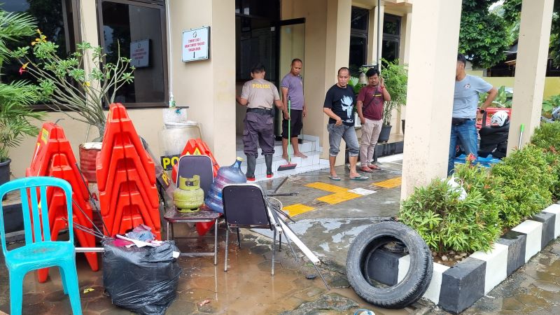 GOTONG ROYONG: Anggota kepolisian Polsek Imogiri bahu membahu membersihkan air dan lumpur sisa banjir akibat luapan Kali Celeng semalam.