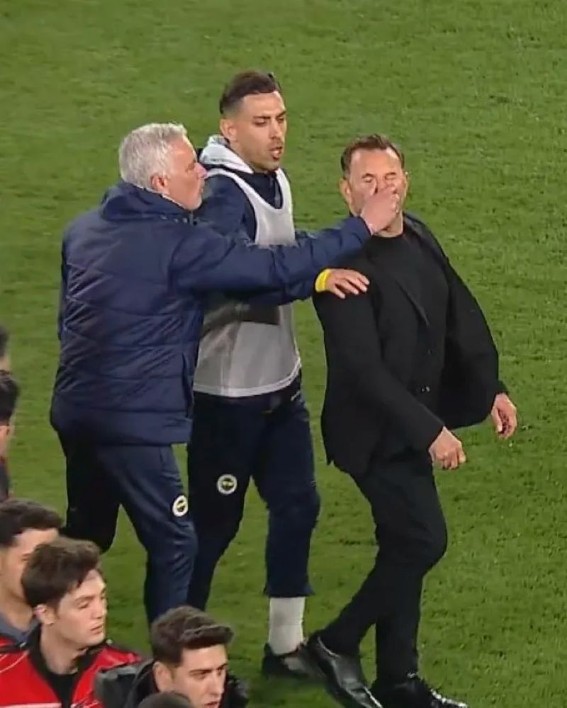 Pelatih Fenerbahce, Jose Mourinho terlihat mencubit hidung dari pelatih Galatasaray, Okan Buruk