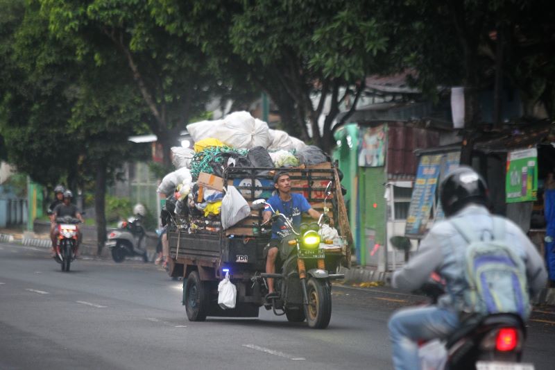 MENUMPUK: Pekerja mengangkut sampah rumah tangga di Jalan Tentara Rakyat Mataram, Kota Jogja Selasa (8/4).