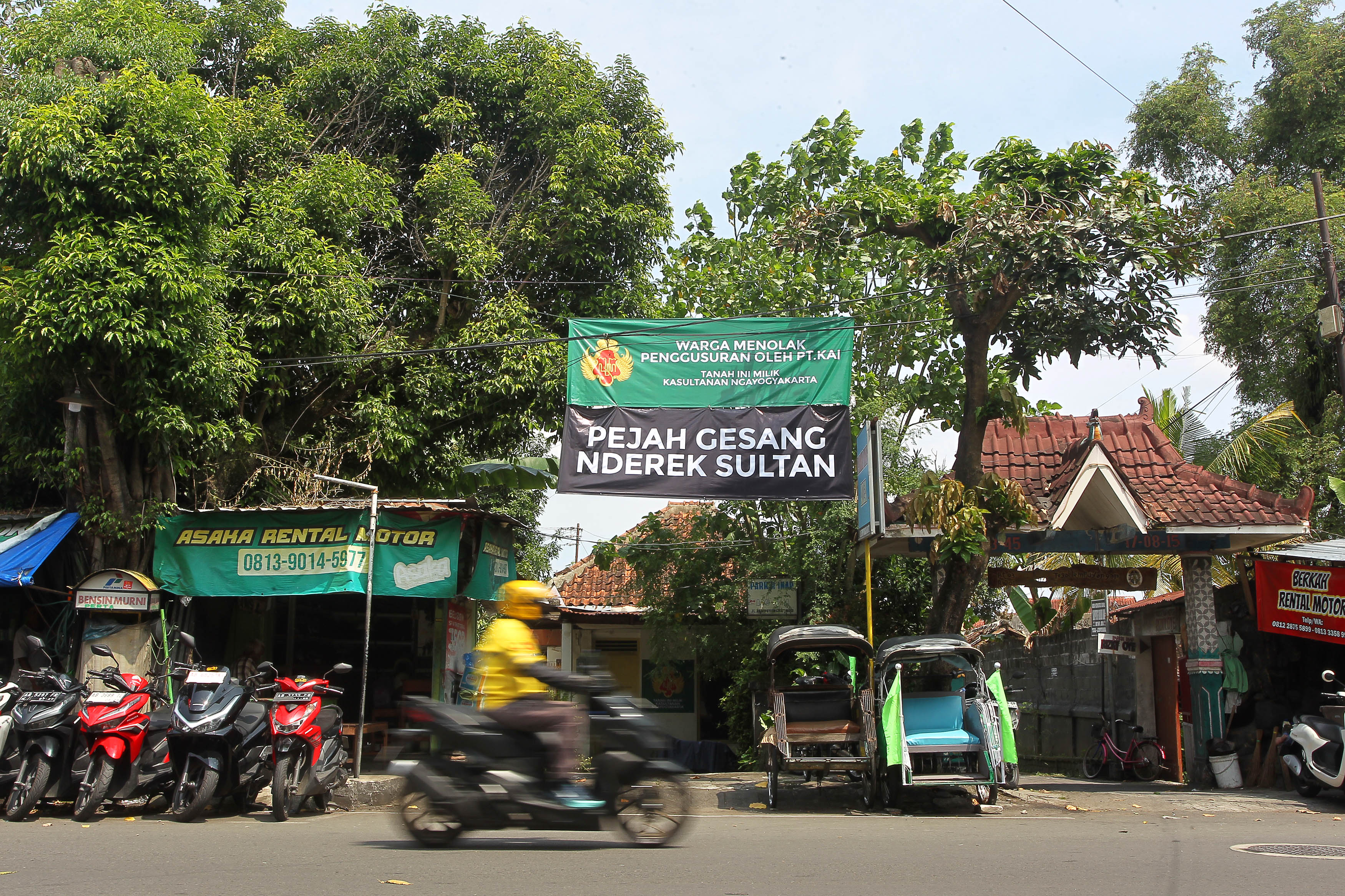 Pengguna jalan melintas di dekat spanduk berisi penolakan warga Tegal Lempuyangan RT 02 RW 01, Kelurahan Bausasran