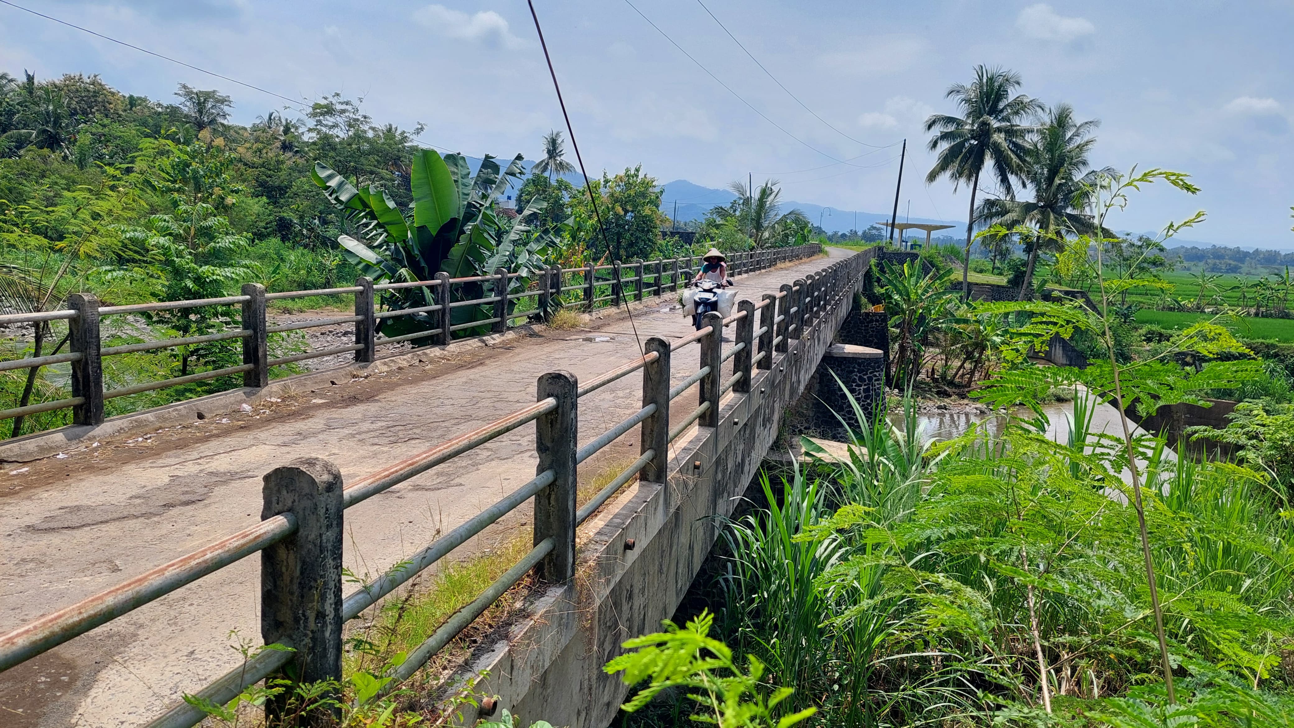 IRIGASI: Masyarakat melewati jembatan talang yang digunakan sebagai saluran air.&nbsp;