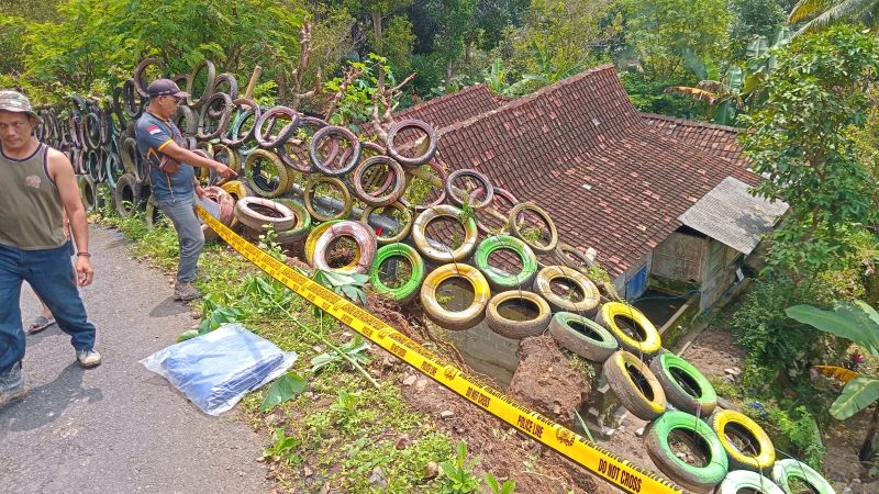 AMBROL: Dinding tanah di jalan kabupaten amblas setelah diguyur hujan.&nbsp;