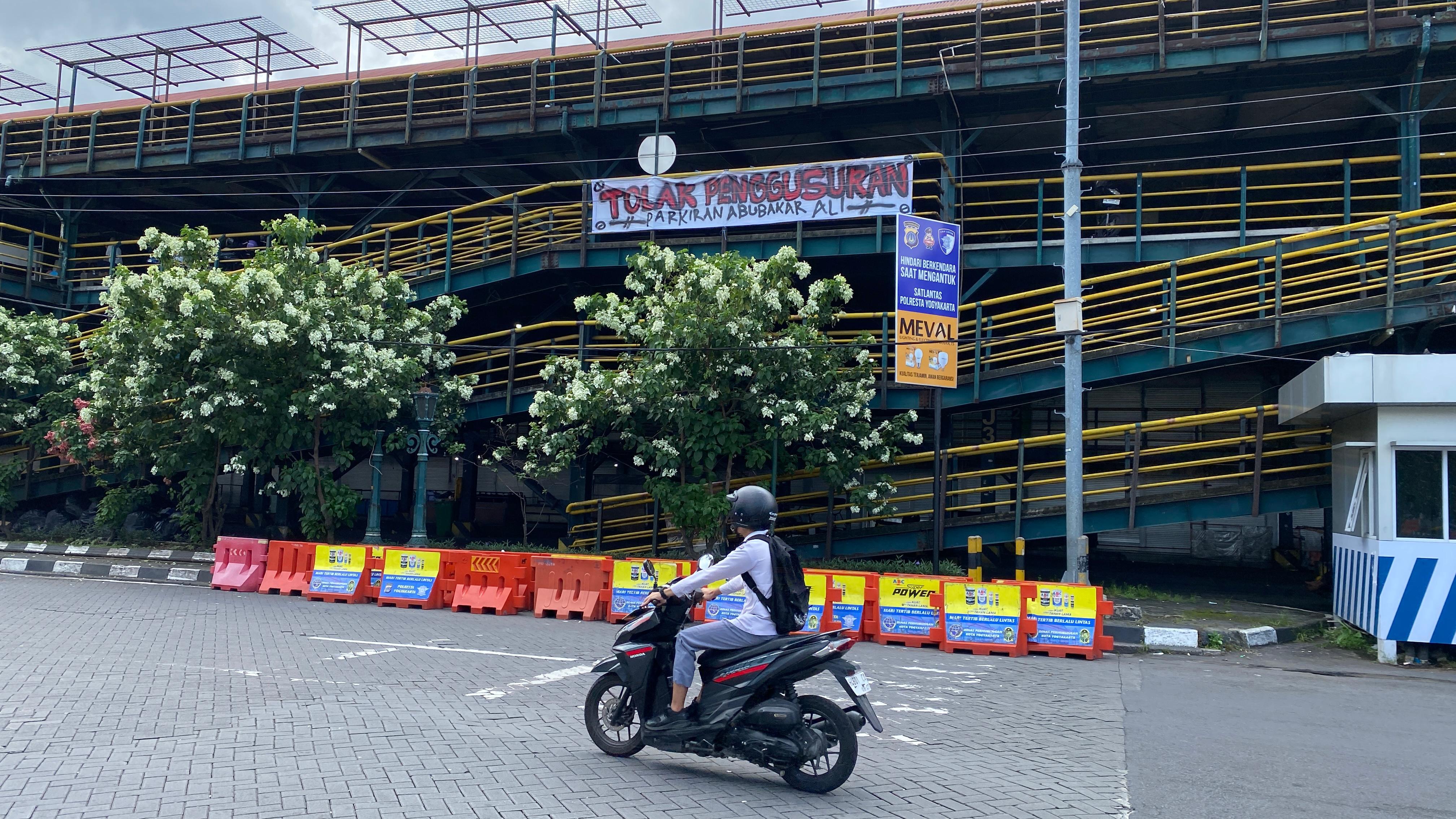 Spanduk aspirasi penghuni TKP ABA yang menuntut pemerintah agar melaksanakan proses relokasi dengan jelas, Senin (14/4/2025).