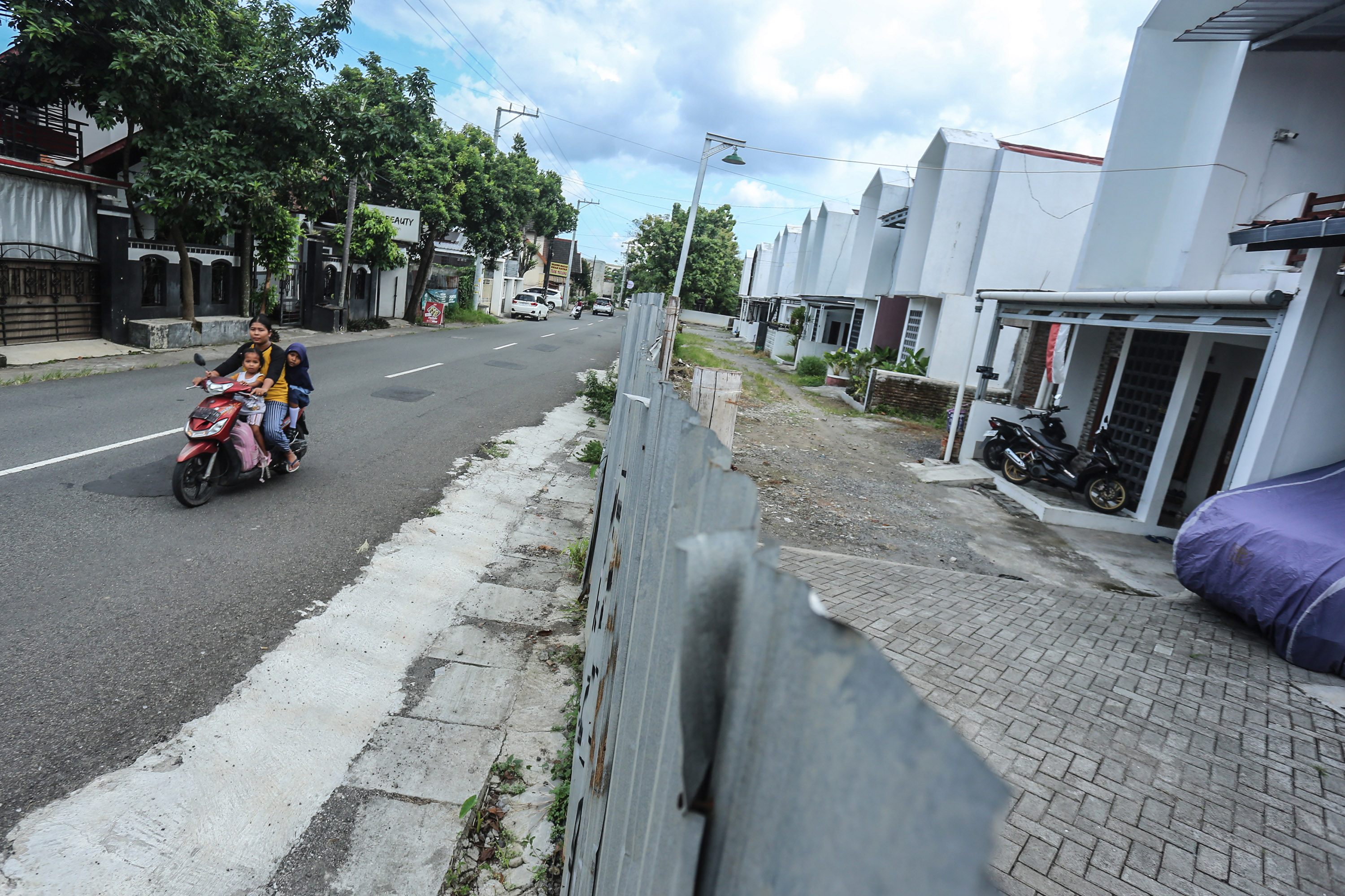 Warga melintas disanping deretan rumahyang dibangun pengembang PT Deztama Putri Sentosa di kawasan Caturtunggal, Depok, Sleman, Selasa (15/4). Bangunan perumahan itu ilegal karena berdiri di atas tanah kas desa (Foto: Elang Kharisma Dewangga).