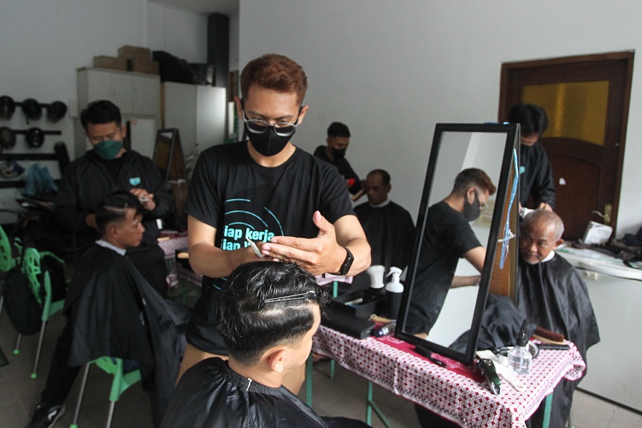 Peserta pelatihan memberikan layanan pangkas rambut secara gratis kepada warga, di Kantor Dompet Dhuafa, Kota Jogja, Rabu (16/4/2025).
