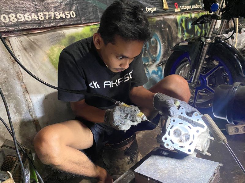 FOKUS: Pemilik bengkel motor GYN Manual Tech Garindra Tegar Indriansyah sedang melakukan kolter pada mesin Vario 125.
