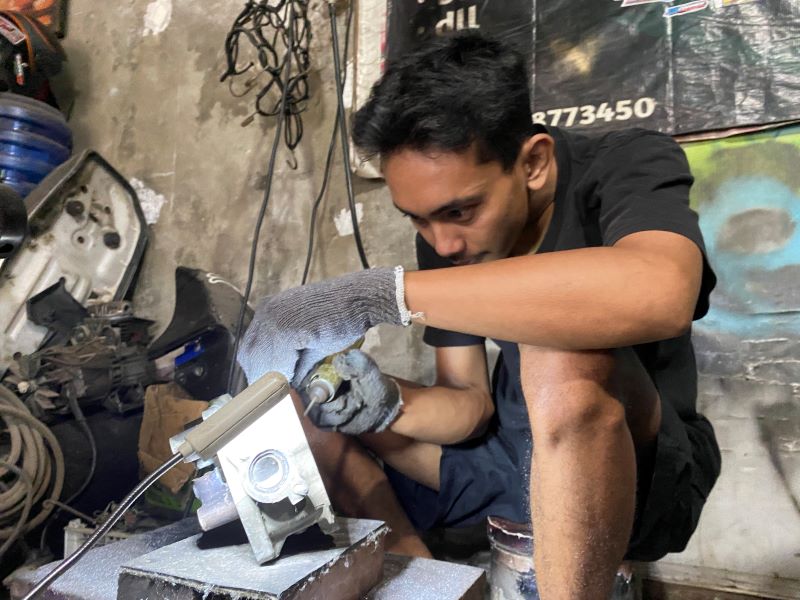 FOKUS: Pemilik bengkel motor GYN Manual Tech Garindra Tegar Indriansyah sedang melakukan kolter pada mesin Vario 125.