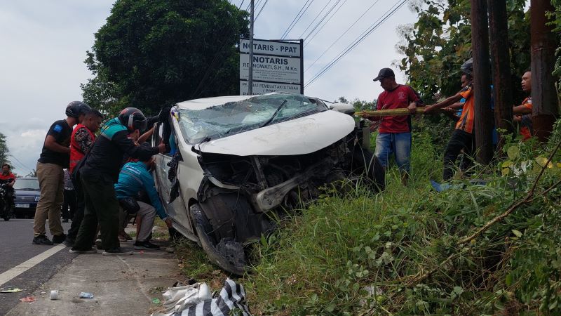 RINGSEK: Relawan saat memeriksa kondisi mobil yang rusak parah akibat kecelakaan di Jalan Jogja-Wates, Sukoreno, Sentolo, Kulon Progo Minggu (20/4).