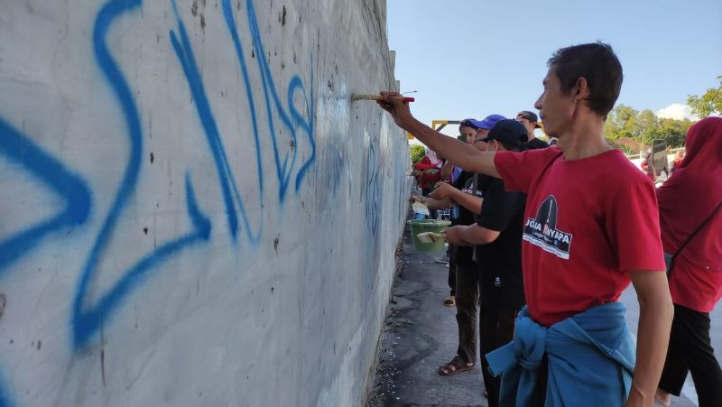 HAPUS: Berbagai lapisan masyarakat menghapus jejak vandalisme di berbagai fasum di perkotaan Wates, Sabtu (26/4).