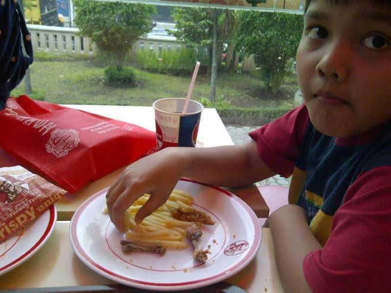 Haznan Aqilla sedang menikmati sajian menu KFC yang berlokasi di Gedung Wisma Hartono Jogja pada 9 Maret 2012. Foto diambil dengan kamera ponsel BlackBerry 9790.