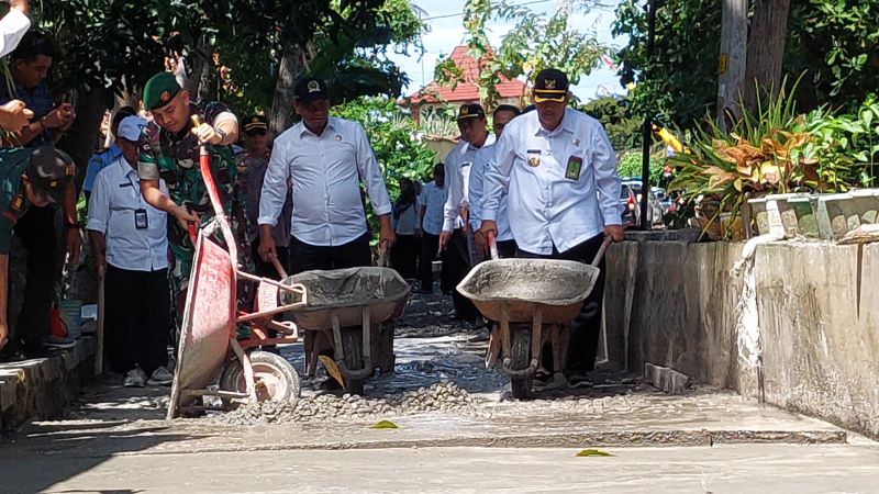 GOTONG ROYONG: Bupati dan warga sekitar melakukan perbaikan infrakstruktur jalan.&nbsp;