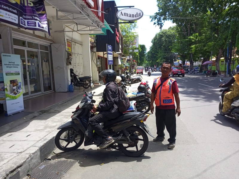 Petugas parkir di Jalan Pemuda, Kebumen sedang mengatur kendaraan di kantong parkir tepi jalan.