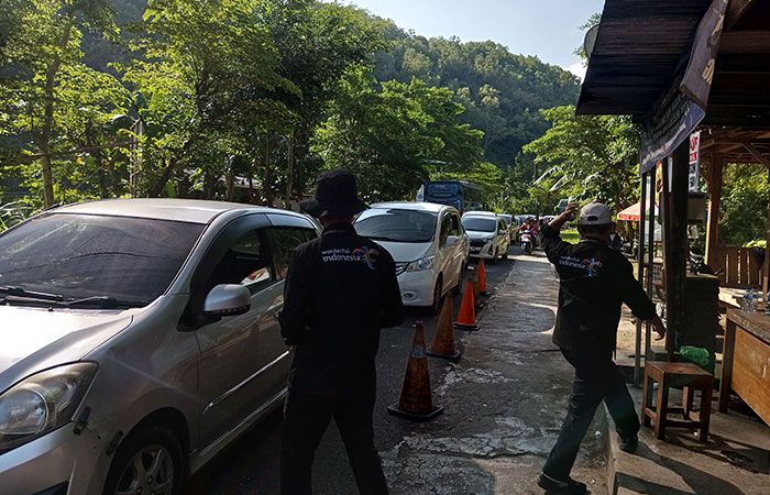 Petugas TPR JJLS Pantai Baron sedang melayani pembelian tiket wisatawan. Terlihat anteran panjang pandat merayap di depan Pos TPR.