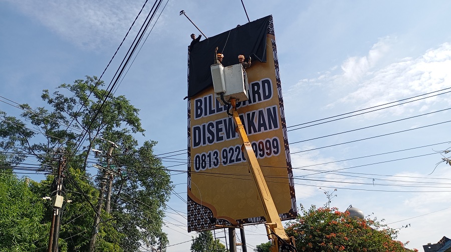 TUTUP: Personel Satpol PP Kota Jogja saat melakukan penertiban reklame ilegal di Jalan Langensari, Gondokusuman, Senin&nbsp;&nbsp;(13/5/2025).