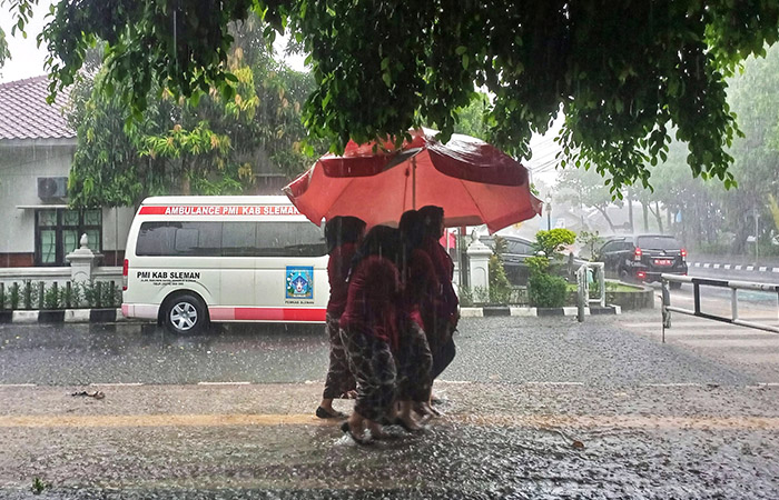 Sejumlah Aparatur Sipil Negara (ASN) menembus hujan untuk bergegas kembali ke kantor mereka di lingkungan Pemkab Sleman, kemarin (15/5).