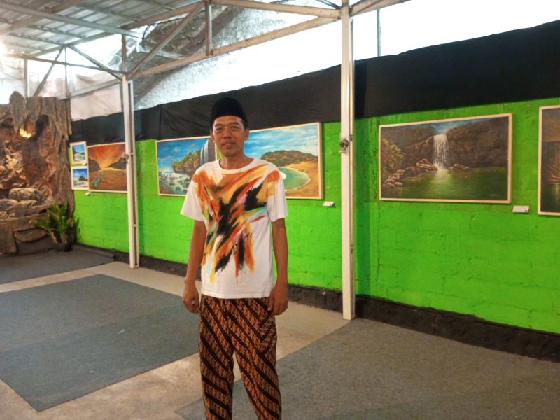 INSPIRATIF: Seniman asal Gunungkidul Tri Joko Purnomo sedang berdiri di tengah-tengah karya-karyanya dalam pameran tunggal Menggambar Gunungkidul.